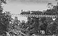 A photo shows a 2-6-0T SS300 class steam engine (later type C11) hauled an SS inspection car passing a bridge on the Bangil-Malang railway line