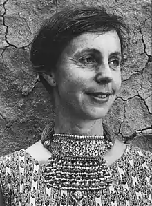 Head and shoulders black and white photograph of a woman with short dark hair and a striking large necklace