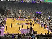 Several Kings players on the court with mostly empty stands