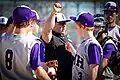 The SMH varsity baseball team takes a moment to huddle with their head coach during an inning break.