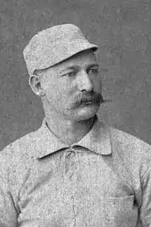 A baseball player is shown sitting, facing slightly right of the camera.