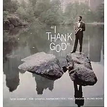 Cooke standing on rocks in a river, wearing a suit