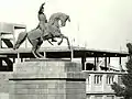 Closeup of the statue with the new town hall under construction on the background, mid-1960s