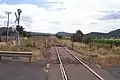 Looking west along the railway line towards Sandy Hollow from level crossing on Bylong Valley Way