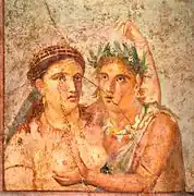 Photograph of a Roman wall-painting - a female figure has her arm around a male one, who grabs her breast. Both sets of eyes gaze across each other, out of the frame.