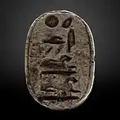 Small greyish oval seal with hieroglyphs on it.