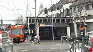 Red train next to canopy-covered platform