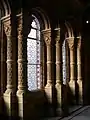 Windows behind the main staircase,  The Natural History Museum, Romanesque round windows, note the colonettes with their carved capitals and elaborately decorated shafts, also typical Waterhouse window glass in geometric patterns and shades of pink and blue