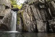 A waterfall you can look up at and feel emerging over the edge of a larger cliff.