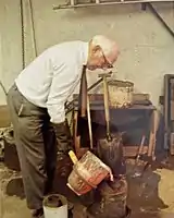 Elderly man pouring molten metal