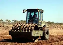 Large roller "sheepsfoot" compactor for use on soil