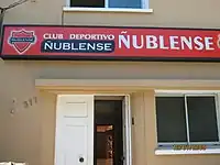 Beige storefront with red sign