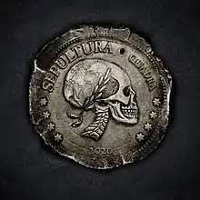 The obverse side of an ancient-looking tarnished silverish coin featuring a side-view portrait of the head and neck a skeleton looking to the right and wearing a laurel wreath. The visual portion of the skull's neurocranium features a simple map of the Western hemisphere. The emblem of the coin, which wraps most of the way around the coin, has, in order, four stars, SEPULTURA, QUADRA, and then four more stars. A hole appears between SEPULTURA and QUADRA. Below the portrait is the year 2020. The coin appears against a rough dark gray sooty-looking background.