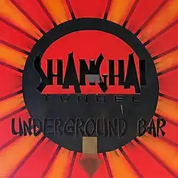 Black, orange and red logo with the text "Shanghai Tunnel Underground Bar" and an arrow pointing downward