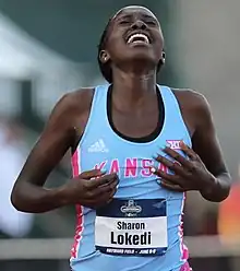 Black woman in a pale blue top.