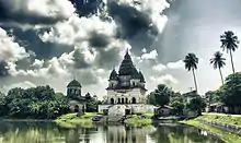 Image 5The pictured Shiva Temple is situated in Puthia Bazar of Rajshahi District. It was built on a hing plinth on the southern bank of a large tank. The temple is a 19.81 meter square building and total height is 35.03 meter. It is a Pancha Ratna type building consists of a Garbhagriha and a surrounding verandah. Rani Bhubanmoye Debi built this temple in 1823 AD.Photo Credit: Nasir Khan Saikat