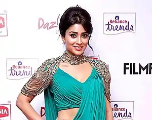 Shriya Saran is seen smiling at the camera.