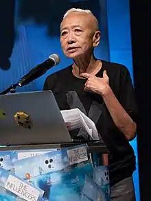 Person standing in front of a podium with a laptop