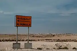 A road sign for Al Huwaila