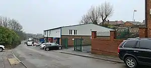 Modern industrial units stretching away from camera position along alignment of former rail tracks