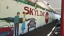 Photograph of a mural of cars and people, with the text "Skyline" and Coca-Cola's logo