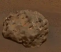 Figure 8. An example iron-nickel meteorite, Heat Shield Rock, with many hematite spherules in the background. Heat Shield Rock can also be seen in Figure 3 as a small dot about 20 m to the left of the discarded heat shield (hence the meteorite's name). It is large. Its longest dimension is 31 cm, i.e. roughly basketball-sized. Large iron-nickel meteorites were occasional featured finds by Opportunity, the rover found six of them. Image taken on Sol 346 (2005-02-01).