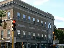 Three-story brick building with a marquee in the lower right