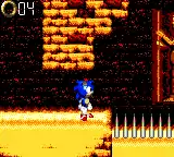 Sonic, a cartoonish blue hedgehog, stands in a desert environment. Spikes can be seen in front of him, and a counter displaying rings is in the upper left-hand corner.