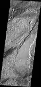 Southern end of Enipeus Vallis is about 10 km wide and broadly U-shaped in profile. The western wall of the valley has a straight NE orientation similar to that of fractures in the Noachian plateau materials to the east. This suggests that the valley formed along pre-existing faults. (THEMIS VIS image)