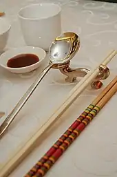 Image 28Photo showing serving chopsticks (gongkuai) on the far right, personal chopsticks (putongkuai) in the middle, and a spoon. Serving chopsticks are usually more ornate than the personal ones. (from Chinese culture)