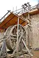 A treadwheel crane or 'squirrel cage' at Guédelon Castle.