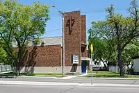 A two-storey brown brick church with a modern bell tower.