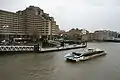 A Thames Clipper catamaran passes the pier (Tower Hotel in the background)