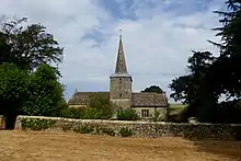 Photograph of the square tower of a stone church spire