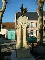 The garlanded war memorial at St Riquier