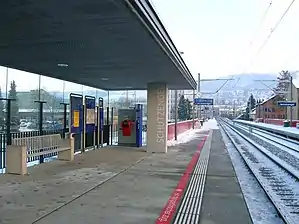 Canopy-covered side platforms surrounding double-tracked railway line