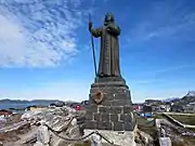 Statue with houses of Nuuk in the background