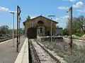 The end of the station building with a disused freight siding.