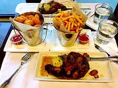 A ribeye steak meal with fries and tater tots