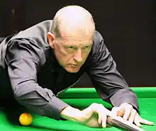 Steve Davis playing a shot with a rest