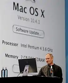 Man in black shirt conducting onstage computer demonstration