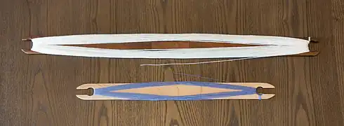 Two stick shuttles, 24" and 16" long, both wound with 8/2 yarns