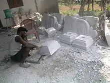 A man carves stone with an electric tool