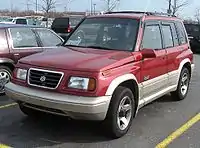 Suzuki Vitara with longer bumpers, wheel arches, side body mouldings, larger grille and powered by V6 engine. This model is known as Escudo V6 in Japan, Sidekick Sport in North America or Vitara V6/TD elsewhere.