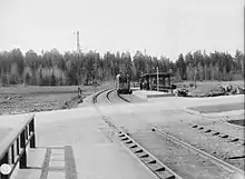 1931, a tram on the tram line Örbybanan heading to Slussen stops at the tram stop Svedmyran in Stureby. The road Tussmötevägen is in the foreground.