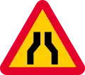 Road narrows on both sides