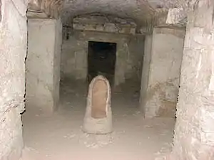 View of burial chamber, showing trace paint on opposing lintel, and urn.