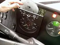 Analogue Tachometer, or Tachograph. A modern tachograph with tachograph chart. Note the teardrop shaped hole as opposed to a round hole.