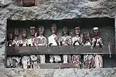 Toraja stone-carved burial site. Tau tau (wooden statue of the deceased) were put in the cave, looking out over the land, from South Sulawesi