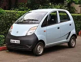 Four-door car with a one-box body style with steel wheels, an air intake located behind the rear passenger door, and no passenger side mirror